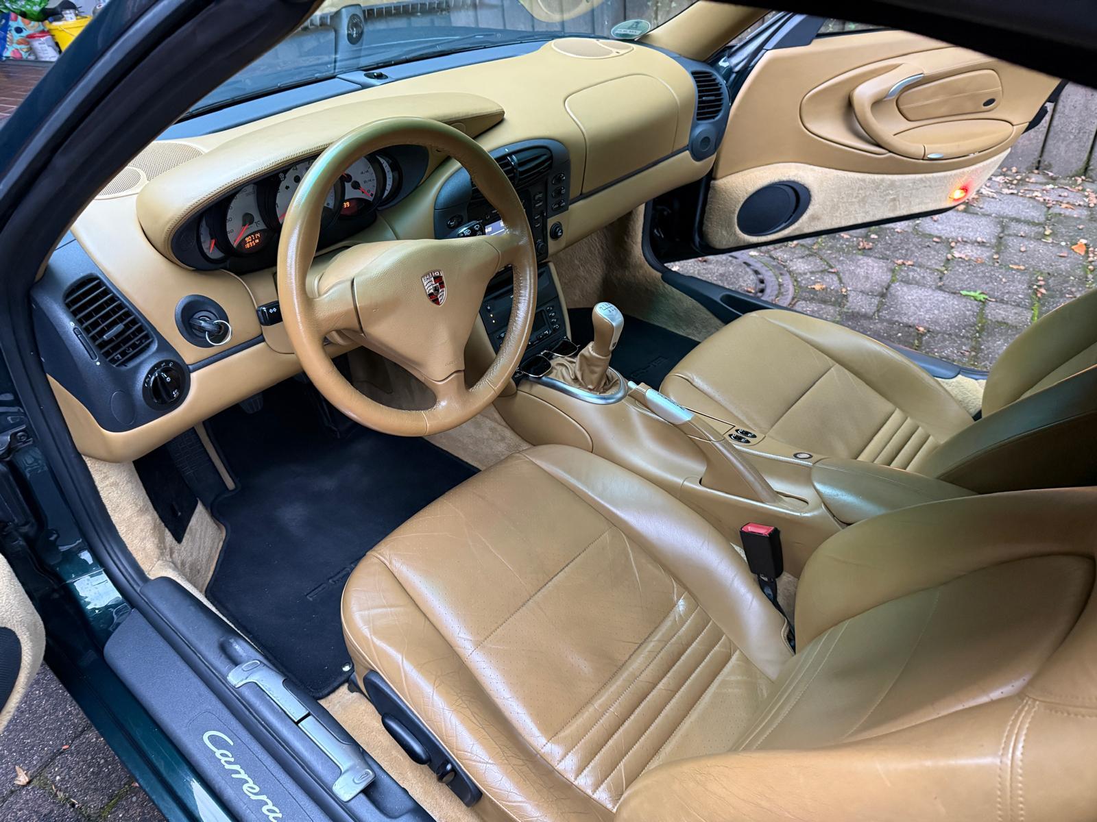 Fahrzeuginnenraum: Blick in ein Auto mit hellbrauner Lederausstattung und Schaltgetriebe.